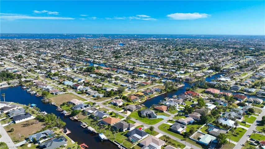 Aerial overview of property's location featuring a nearby body of water and nearby suburban area