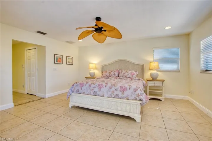Bedroom with light tile patterned floors, ceiling fan, and recessed lighting
