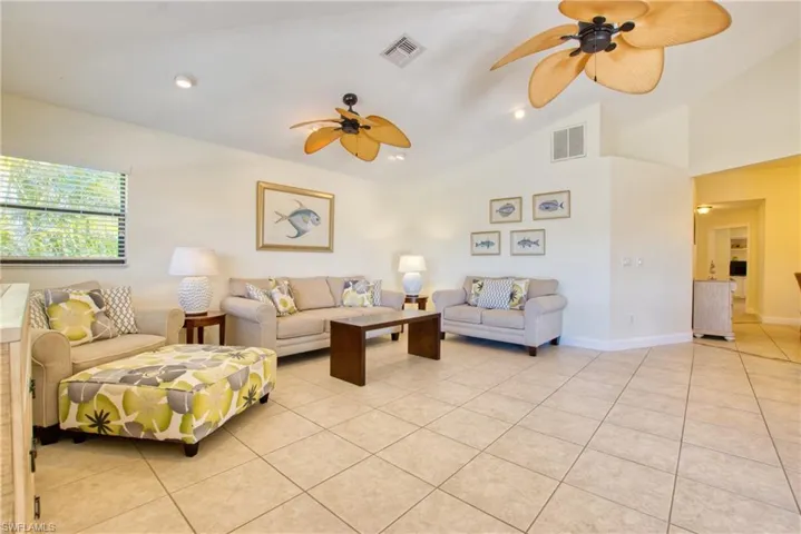 Living area with light tile patterned floors, recessed lighting, a ceiling fan, and high vaulted ceiling