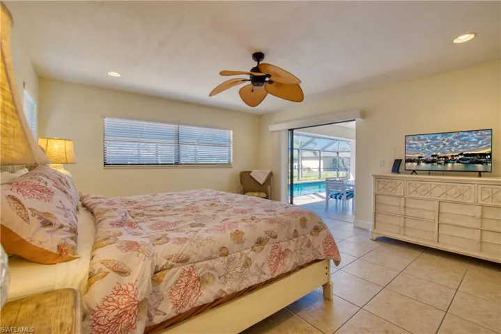Bedroom with light tile patterned floors, access to outside, recessed lighting, ceiling fan, and a sunroom