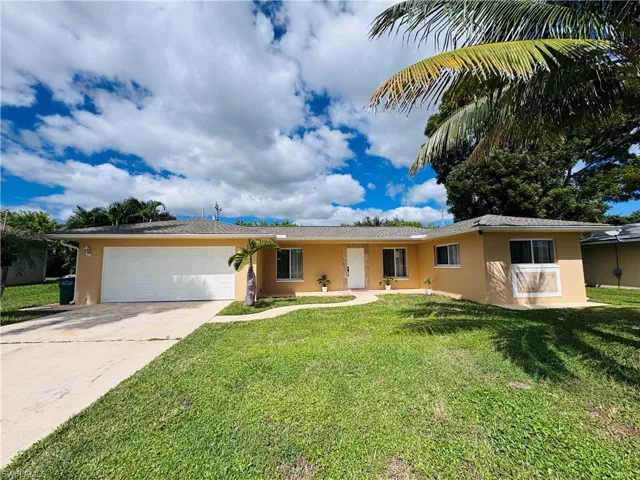 Ranch-style home featuring stucco siding, driveway, a front lawn, and an attached garage