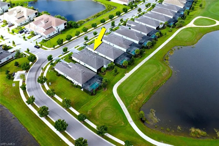 Aerial perspective of suburban area with a nearby body of water and a golf course