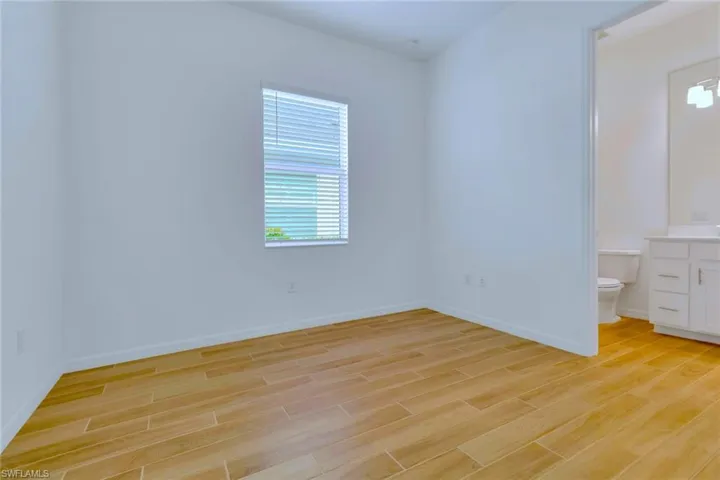 Unfurnished bedroom featuring multiple windows and light wood-type flooring