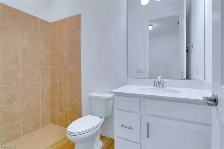 Bathroom with vanity and tiled shower