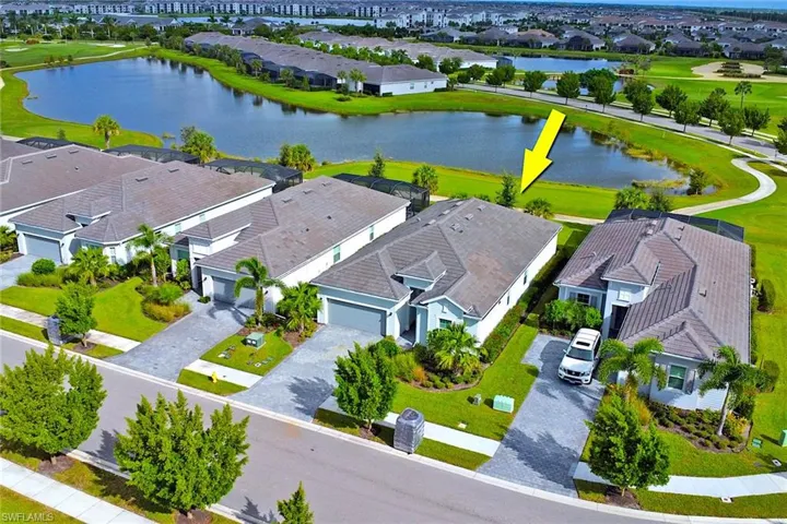 Aerial perspective of suburban area with a nearby body of water and a golf course
