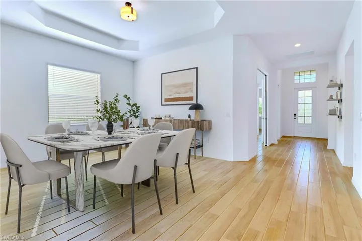 Dining area featuring a raised ceiling and light wood-style flooring