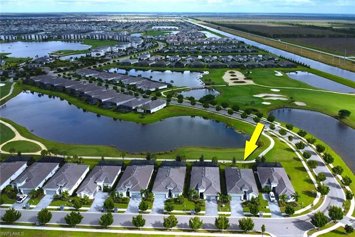 Aerial overview of property's location featuring nearby suburban area, a golf club, and a large body of water