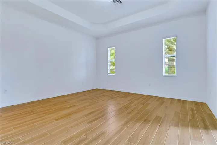 Spare room featuring a raised ceiling and light wood finished floors