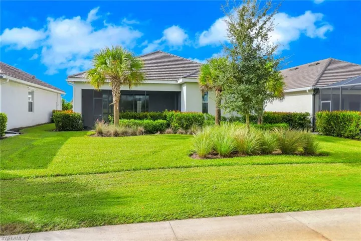 View of front of property featuring a front yard, stucco siding, and a sunroom