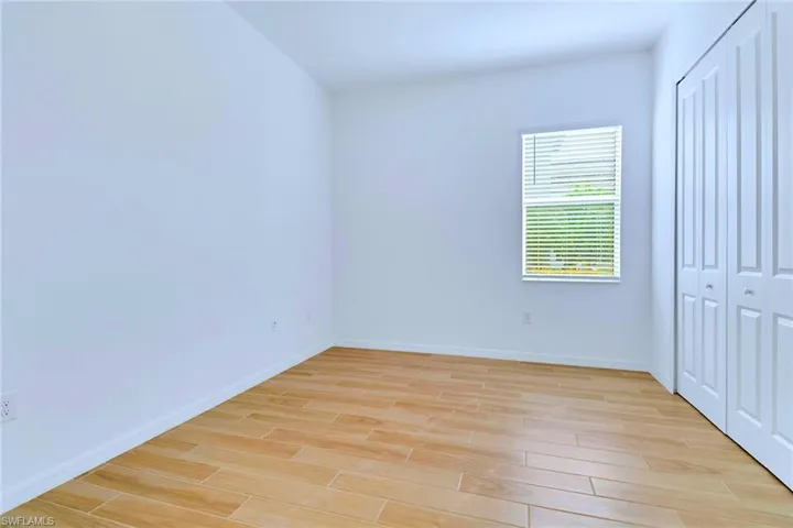 Unfurnished bedroom featuring wood finish floors and a closet
