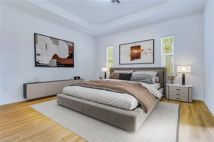 Bedroom featuring a raised ceiling and wood finish floors