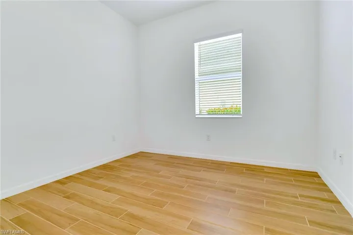 Empty room featuring baseboards and wood tiled floors