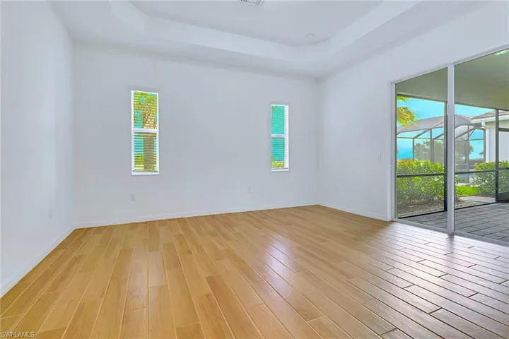 Unfurnished room with a raised ceiling and light wood-style flooring