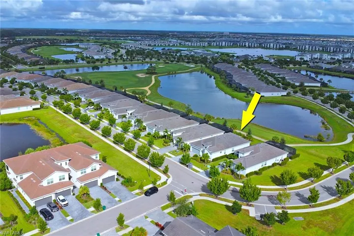 Aerial view of residential area with a large body of water and a golf club