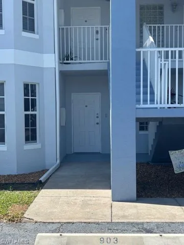 Entrance to property with stucco siding and a balcony
