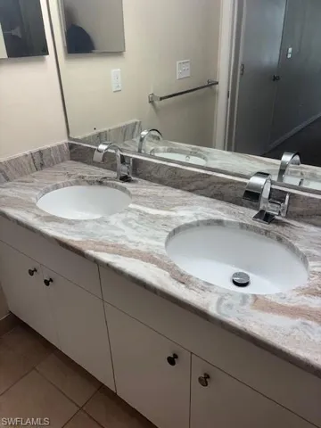 Full bathroom with double vanity and tile patterned flooring