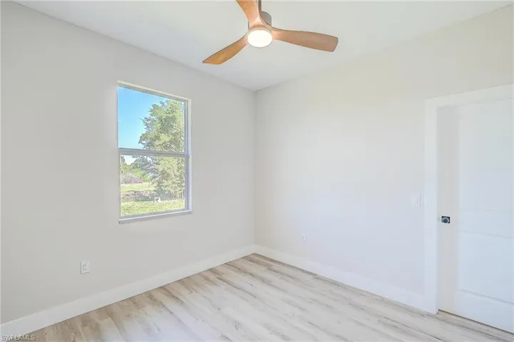 Unfurnished room with light wood-style flooring and baseboards