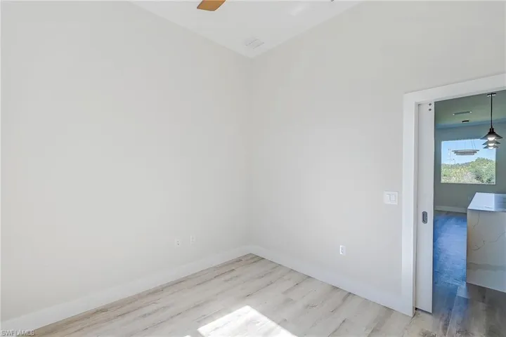 Den - Office with a ceiling fan, light wood finished floors, and vaulted ceiling