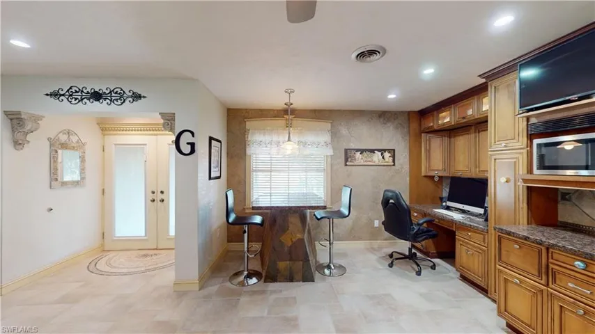 Office area featuring built in desk, french doors, and recessed lighting