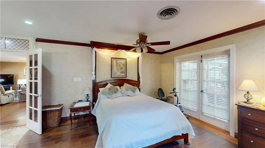 Bedroom featuring wallpapered walls, french doors, access to outside, hardwood / wood-style flooring, and ornamental molding