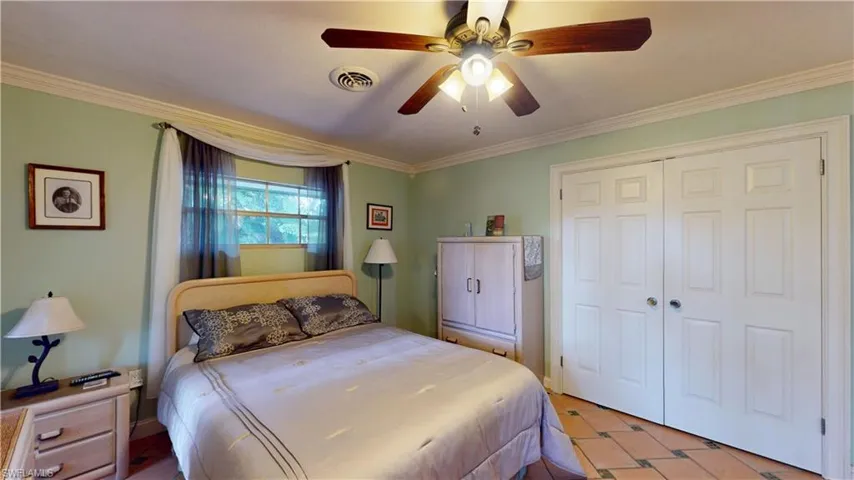 Bedroom featuring ornamental molding, a ceiling fan, and a closet