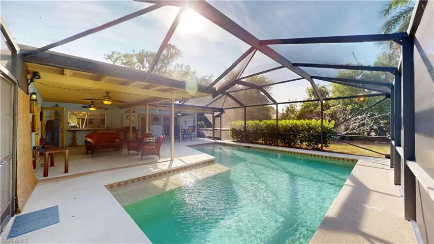 Outdoor pool featuring a sunroom, glass enclosure, a patio area, and outdoor lounge area