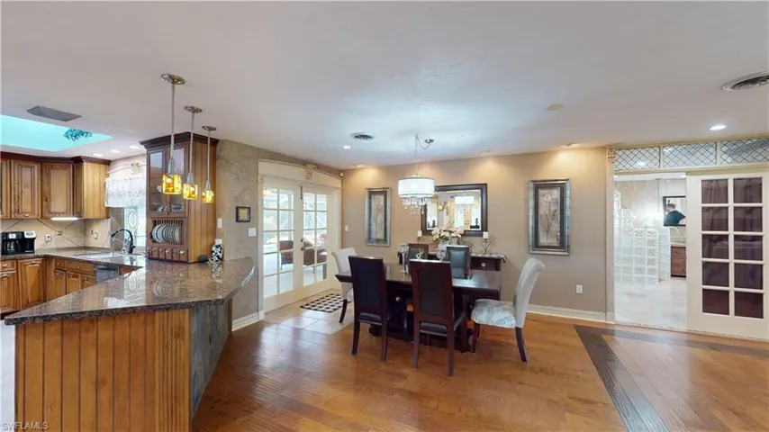 Dining area featuring french doors, light wood-style floors, recessed lighting, and a chandelier