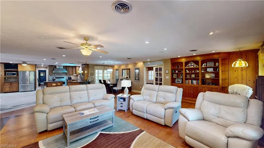 Living area featuring recessed lighting, a ceiling fan, built in features, and light wood-style floors