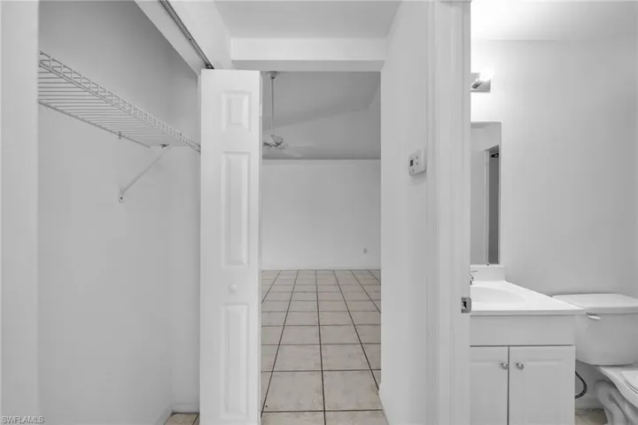 Entryway featuring a bifold door, wire shelving, and tile flooring