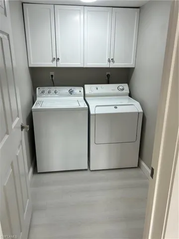 Washroom featuring washer and dryer and cabinets