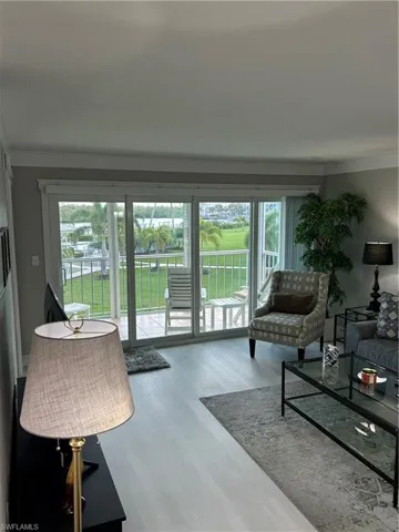 Living room featuring wood-type flooring and crown molding