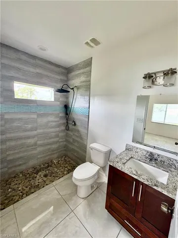 Shower with pebble floor, rain shower head, and horizontal accent tile