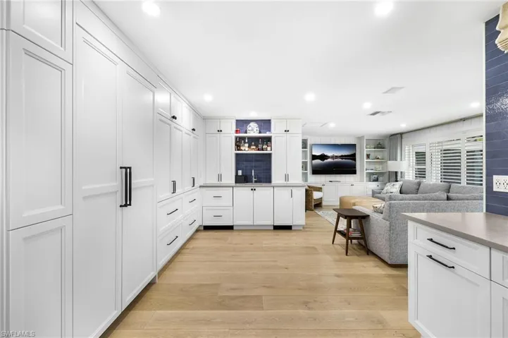 Kitchen featuring hidden appliances and wet bar
