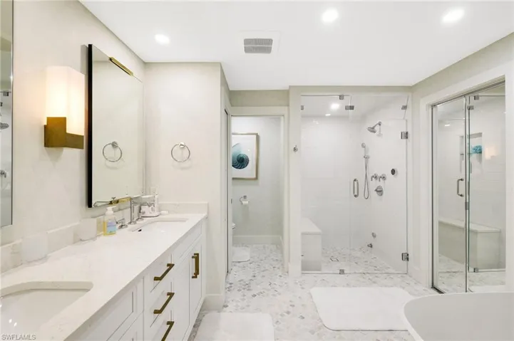 Primary bathroom with dual vanity, walk in steam shower with seat