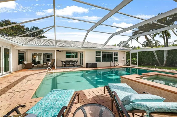 View of pool with an in ground hot tub, a lanai, a patio area, and an outdoor living space