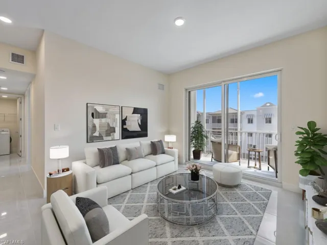 Virtually staged photo. Living area featuring large format tile flooring, and a sliding glass door leading to a private balcony