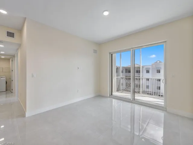 Spacious interior featuring light-toned walls, and large format tile flooring