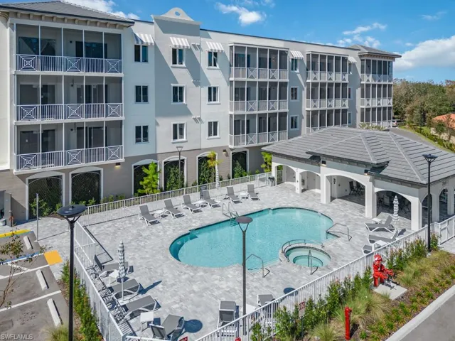 Outdoor recreation area featuring a swimming pool, integrated spa, and an adjacent covered cabana with a tiled roof