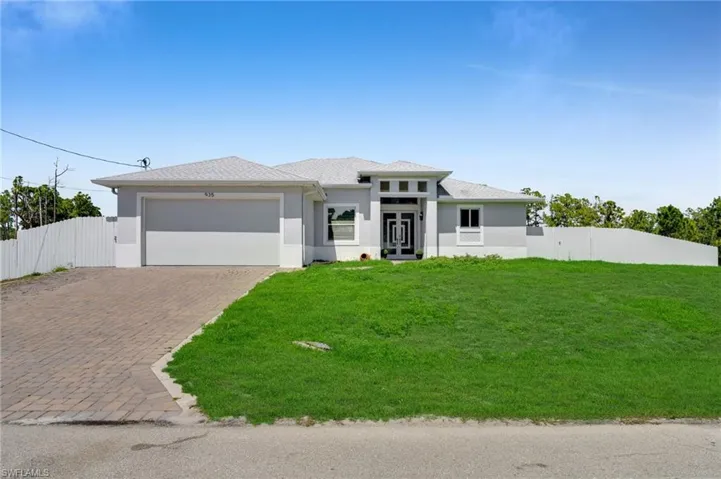 Prairie-style home featuring decorative driveway, a garage, and stucco siding