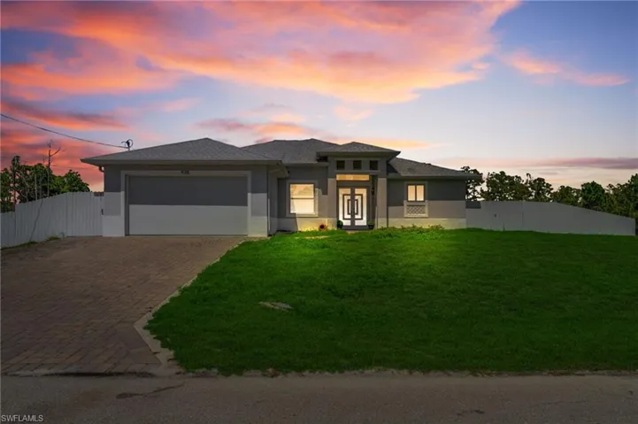 Prairie-style home featuring a garage, french doors, decorative driveway, and stucco siding