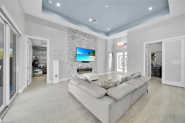 Living room featuring a fireplace and a tray ceiling