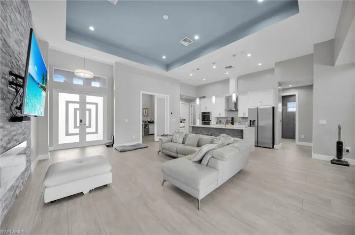 Living room with a raised ceiling and light wood finished floors