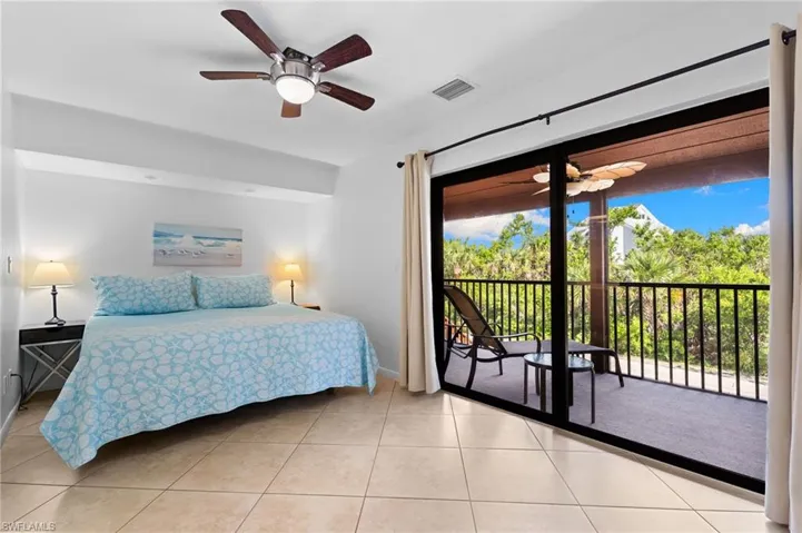 Bedroom with access to exterior, light tile patterned flooring, and a ceiling fan