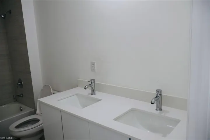 Full bath with double vanity and shower / washtub combination