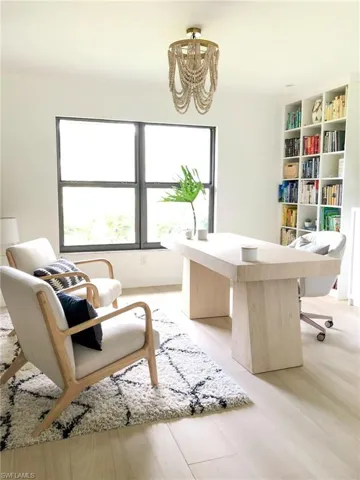 Office area with a chandelier and light wood-type flooring
