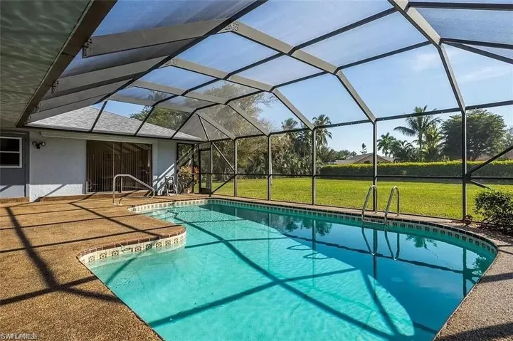 View of swimming pool featuring a lanai and a yard