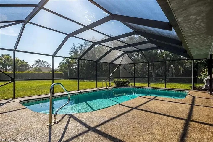 View of pool with a patio, a lanai, and a lawn