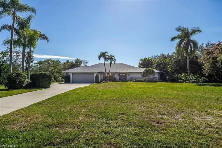 Ranch-style home featuring a garage and a front yard