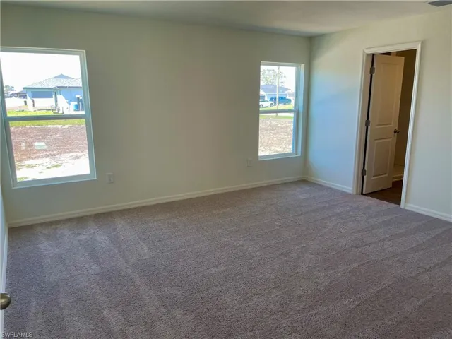 Empty room featuring dark carpet