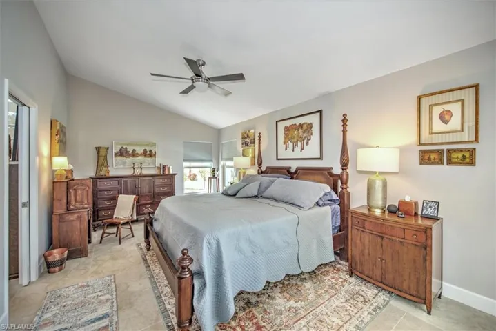 Bedroom featuring baseboards, ceiling fan, and vaulted ceiling